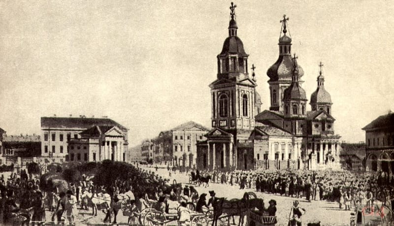 Старая фотография: большая площадь, торговые ряды и возы, вдали церковь с куполом