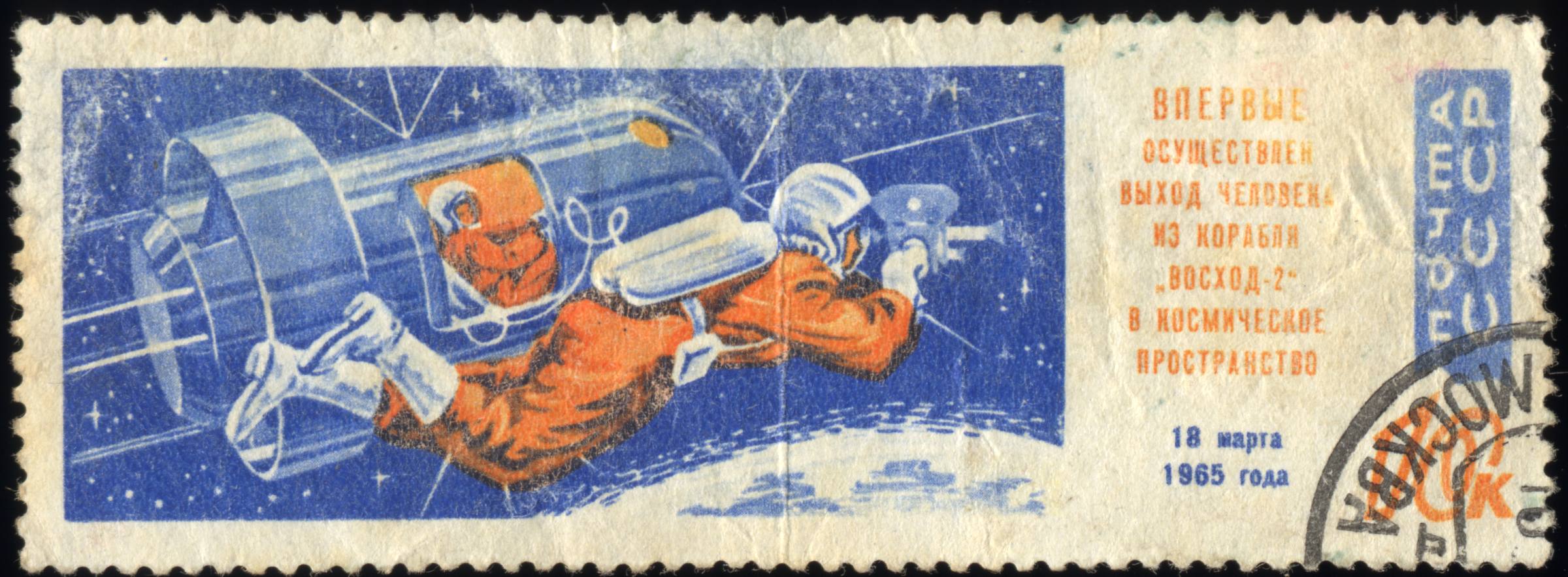 Почтовая марка СССР 1965 года: космонавт в оранжевом скафандре плывёт в космосе у шлюзовой камеры корабля «Восход-2», внизу Земля